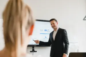 Referent erklärt Inhalte zur Desinfektion an einem digitalen Whiteboard in einer hauswirtschaftlichen Schulungssituation.